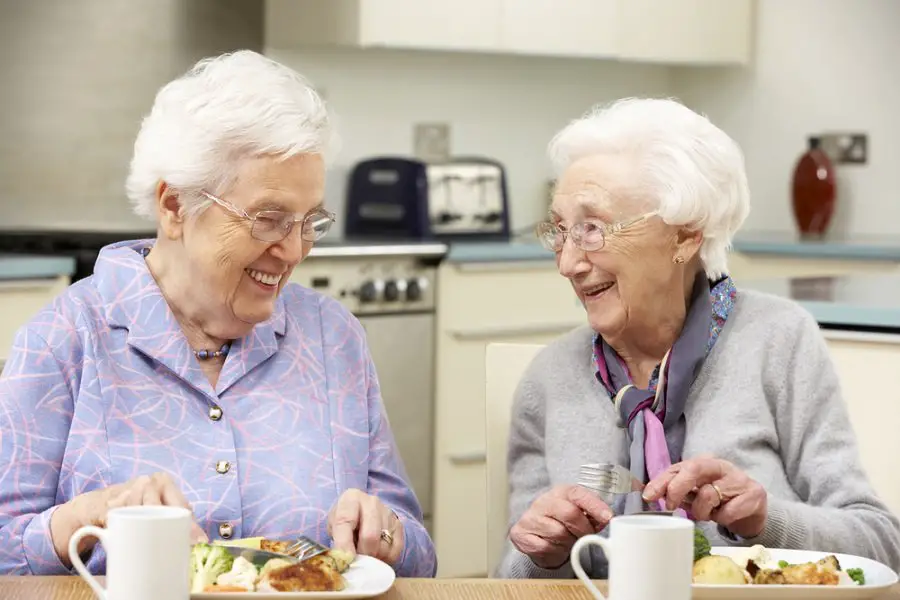 Senior women enjoying meal together at home Senior women enjoying meal together at home